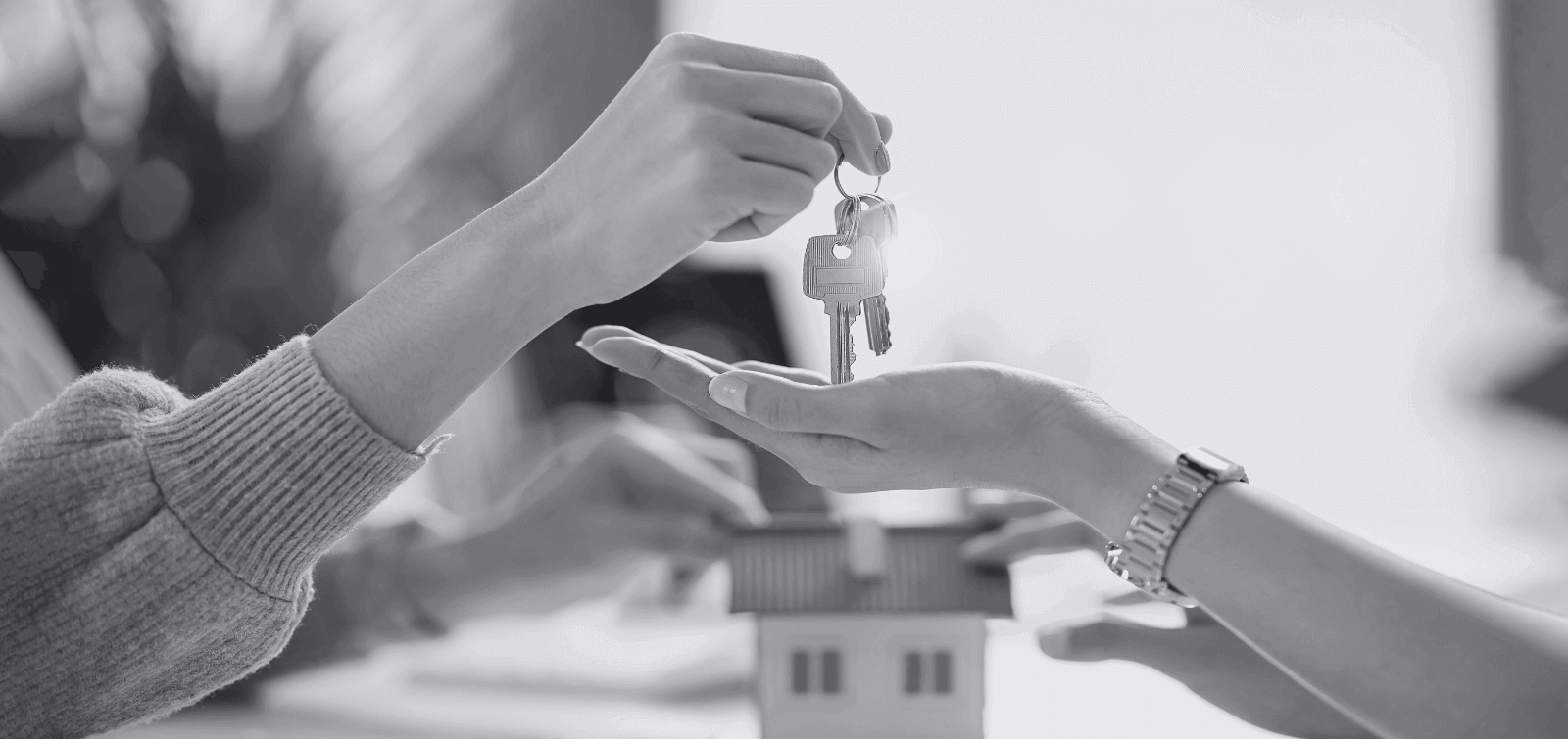 A loan officer hands a new homeowner their home's keys