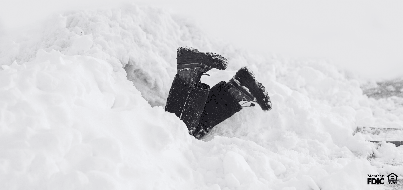 feet sticking out of large snowdrift