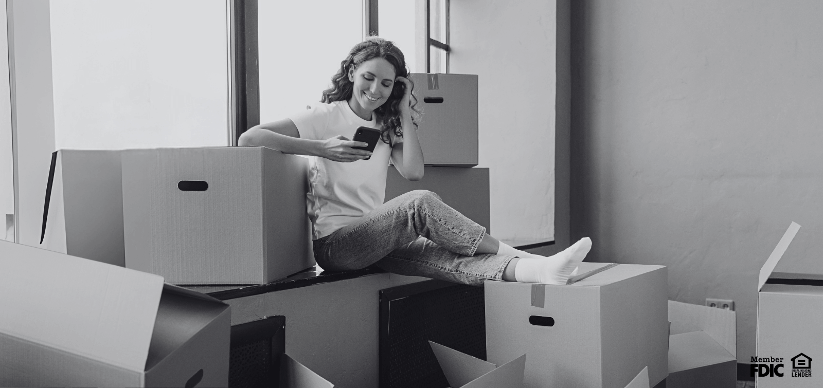 A woman takes a break from packing to check her banking through her mobile ap.