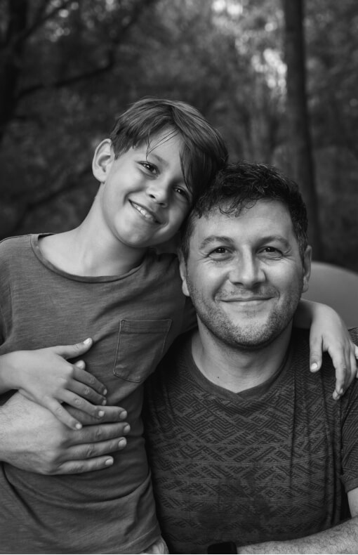 Father and son smiling together outside